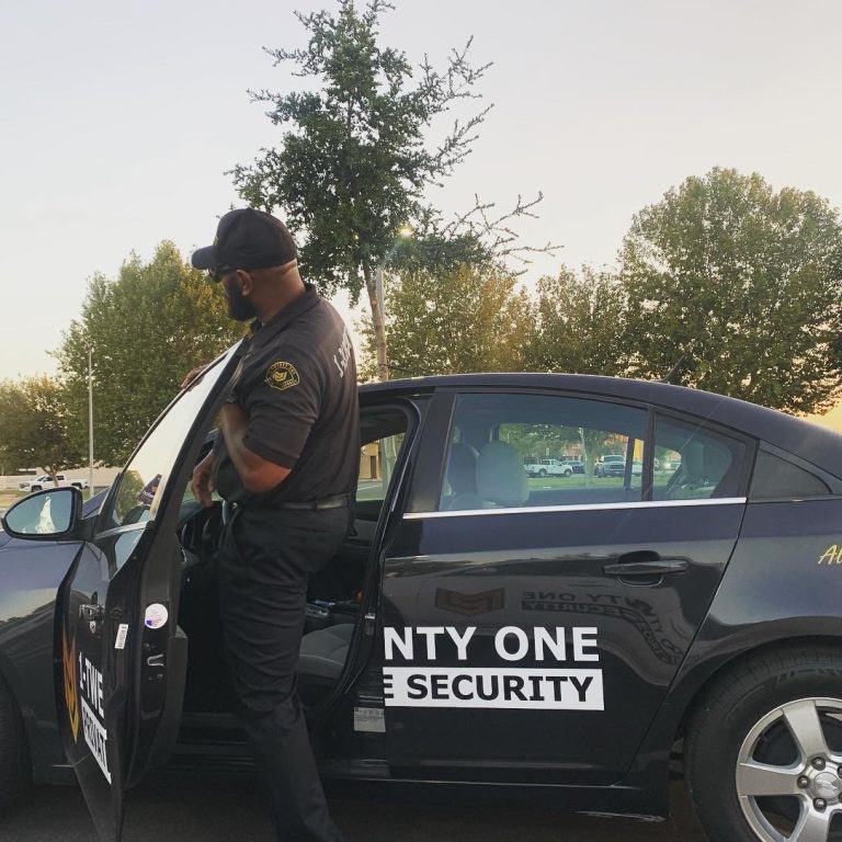 Security officer exiting a marked patrol vehicle for a property check