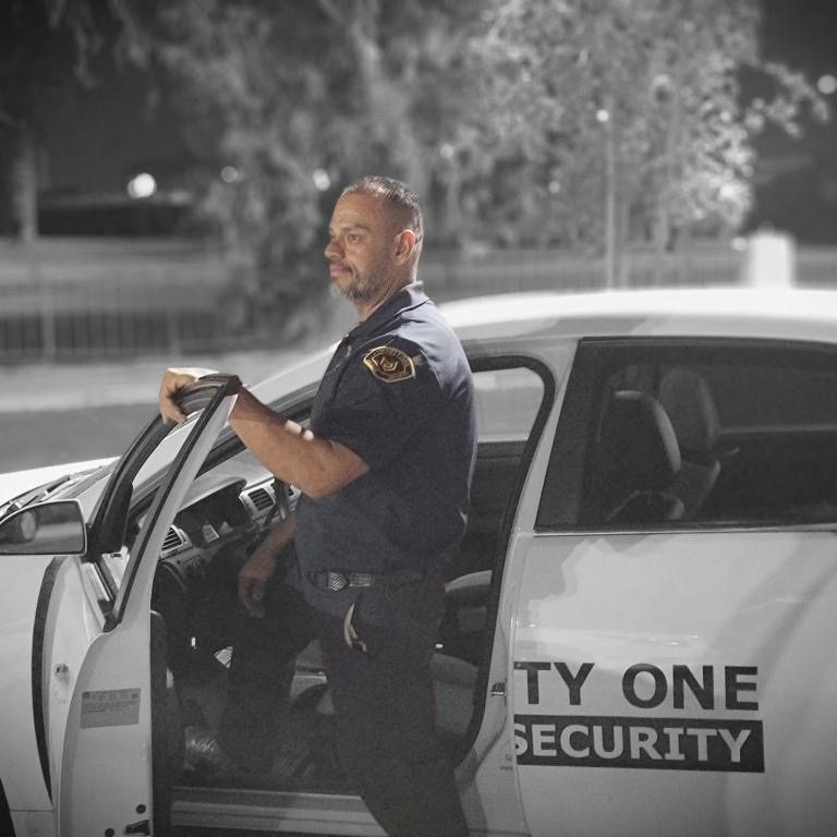 1-Twenty One Security mobile patrol officer beside a marked security vehicle