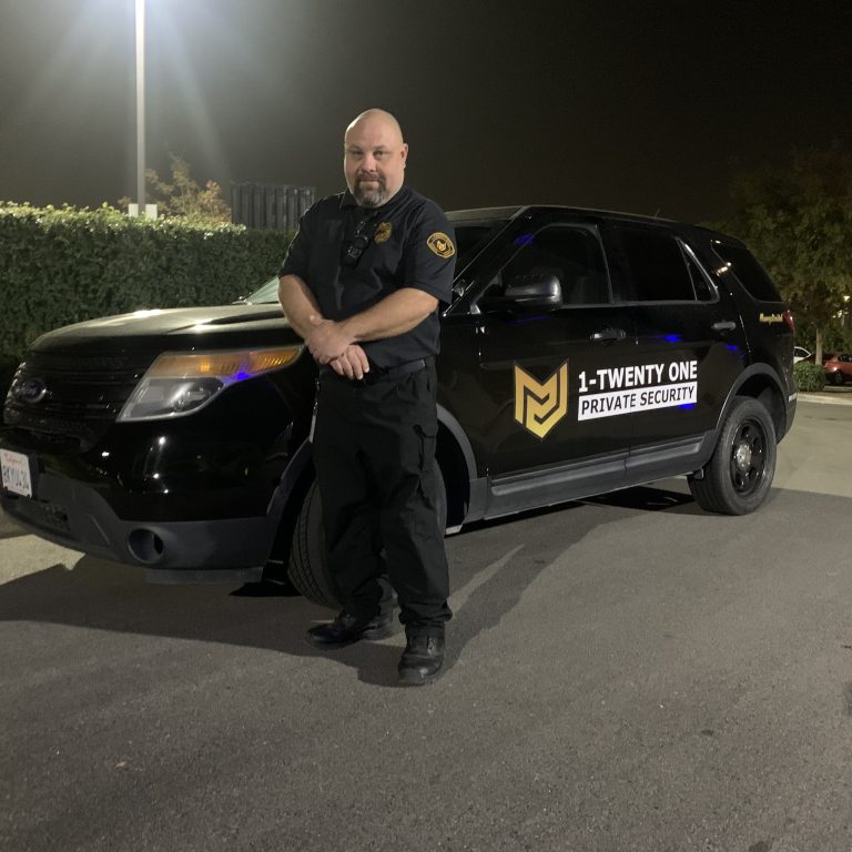 1-Twenty One Security patrol officer beside a marked patrol vehicle